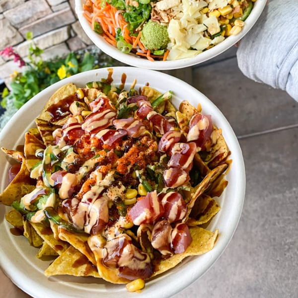 Two Poke Poke Fish Bar bowls, one with poke nachos and the other a traditional poke bowl.